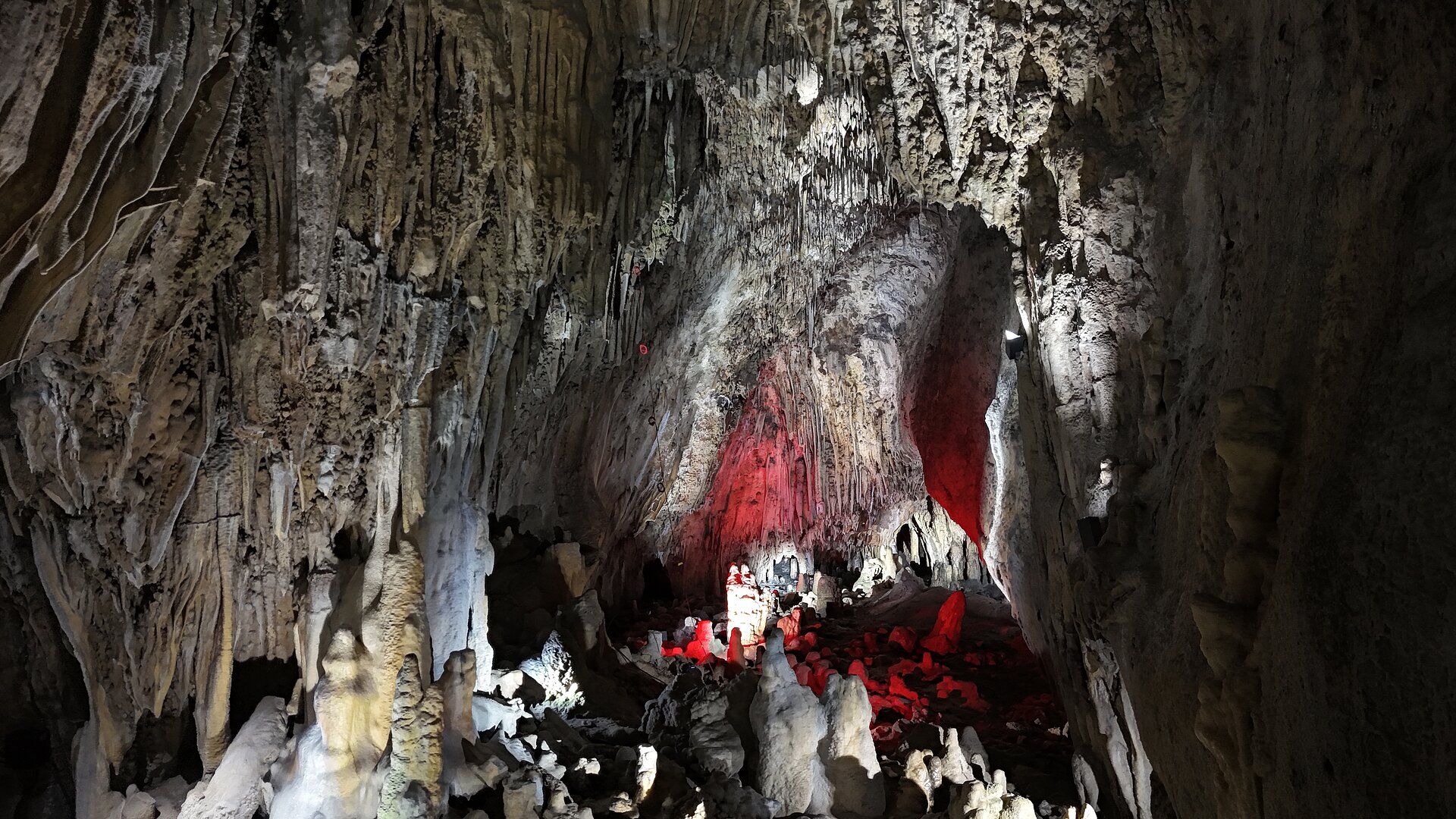 Tropfsteinhöhle in rot, lila und grünes Licht getaucht